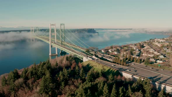 Fog rolls into and under the Tacoma Narrows Bridge in Puget Sound 4K UHD