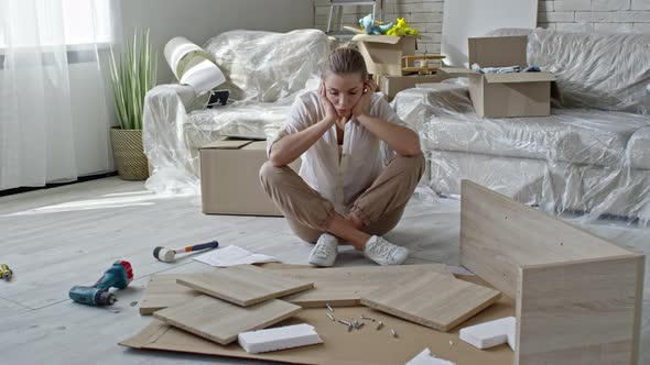 Confused Woman Assembling Furniture alt