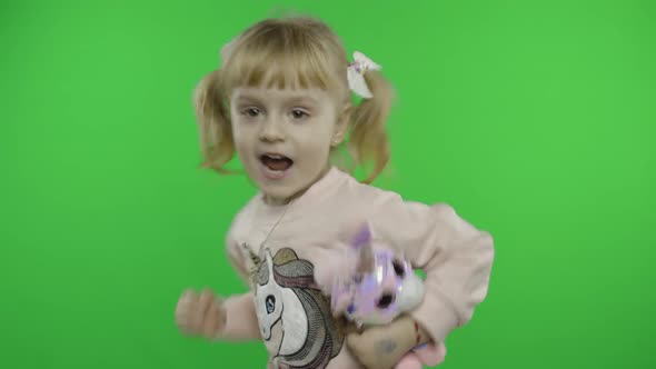 Positive Girl in Sweatshirt Dancing with Unicorn Toy. Happy Child. Chroma Key