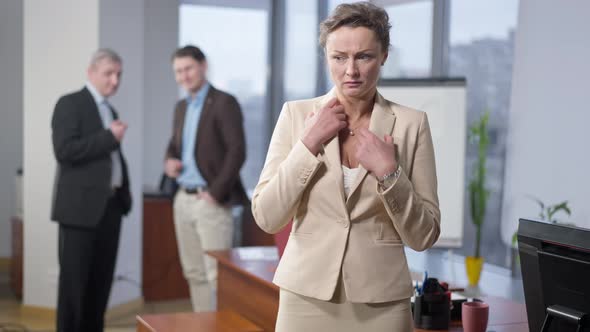 Portrait of Anxious Stressed Beautiful Woman Standing in Office with Male Colleagues Discussing