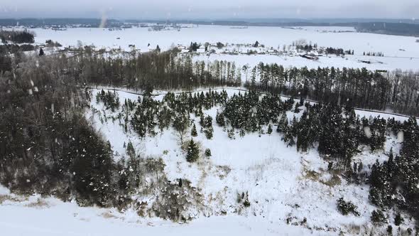 Winter wonderland landscape with snow covered slope of Juniper valley in Lithuania during snowfall