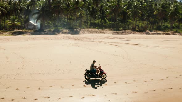 Man Driving a Motorcycle on Beach