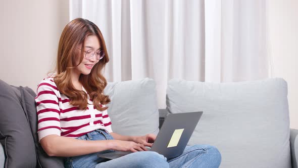 Young Asian woman shopping online via the internet with a credit card.