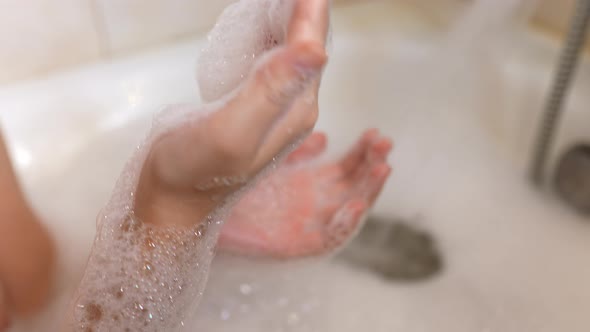 Woman Blows It Soap Foam in the Bath From Her Hands