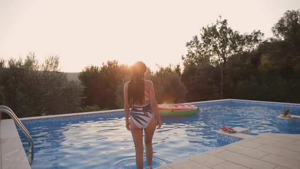 Woman Relax in Swimming Pool at Sunset