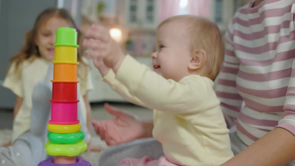 Woman Mother Plays With Two Children Girls Toys In The Room