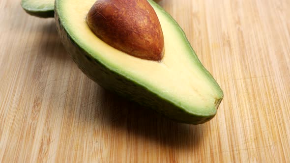 Sliced avocado on a wooden chopping board. PAN UP SHOT.