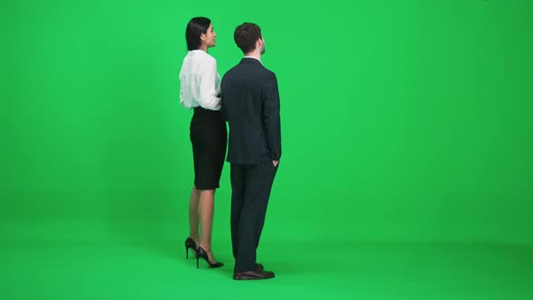 Man and Woman in Suits Stands in the Green Space of the Chromakey They Discuss Subjects While