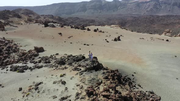 Tenerife, Lunar Landscape in the Crater of the Teide Volcano. Woman and a Man in White Clothes Stand