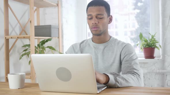 Serious Young African American Man Working on Laptop