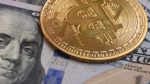 Close-up of dollar bills and bitcoins rotate.