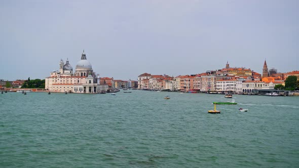Boats Sailing At Venetian Lagoon With Santa Maria della Salute Basilica In Venice, Italy. - POV