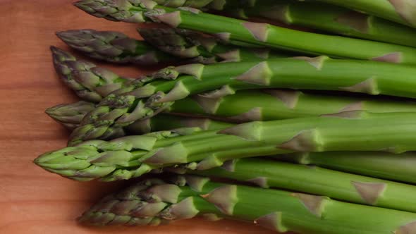 Rotating Green Fresh Asparagus on Wooden Background Trendy Vegetable Background Healthy Food Concept