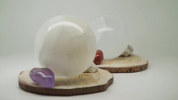 Precious White Crystal Balls On Top Of A Wood With Sea Shells And Gem Stones - Close Up Shot