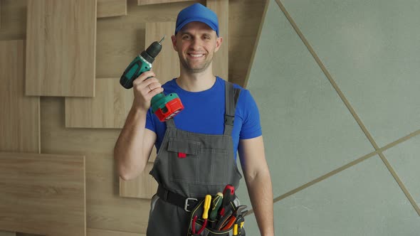 Repairman Stands with a Screwdriver and Smiles in the Room