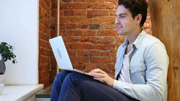 Web Video Chat on Laptop by Young Man, Sitting on Stairs