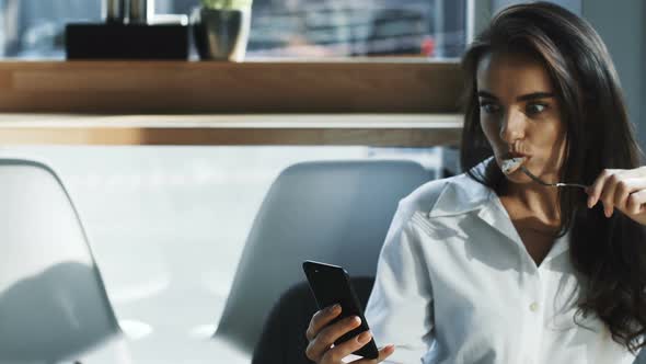 Pretty Woman Eating Meet and Looking To Her Phone with Surprised Face