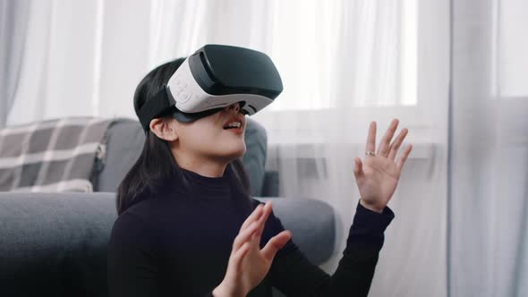 Excited Asian Woman with VR Goggles Experiencing Virtual World