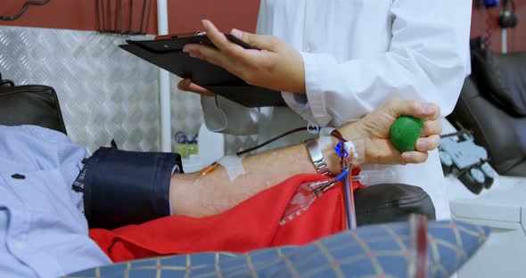 Physician checking senior man donating blood 4k