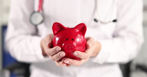 Doctor Holding Red Piggy Bank with Money in His Hands  Movie Slow Motion