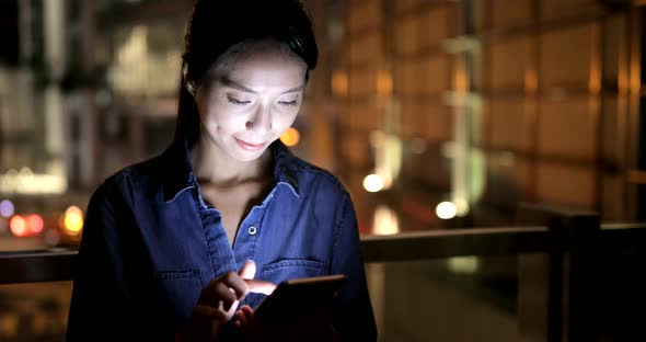 Young woman working on mobile phone at night 
