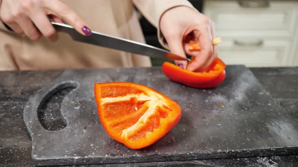 Woman Cuts Fresh Red Bell Pepper Preparing Salad for Family