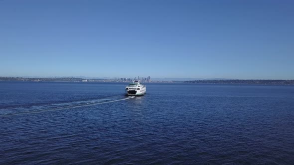 Aerial follow of the Seattle Ferry and downtown Seattle Washington city skyline in the distance.