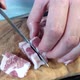 A woman cuts a large piece of pork meat with a knife. Meat with fat layers, pork neck. 4k - VideoHive Item for Sale