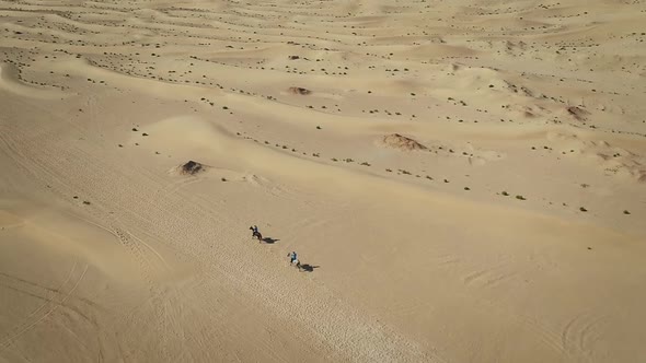 Aerial view of people riding horses in the desert of Al Khatim in Abu Dhabi.