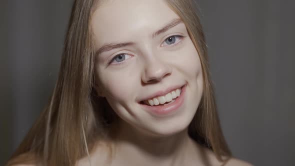 Young Woman Open Eyes on White Background. Close Up of Smiling Girl Looking at Camera in Studio