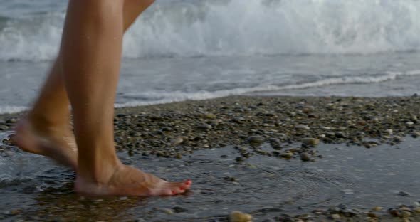 Lady Legs Step on Wet Pebbles and Sand on Ocean Coastline