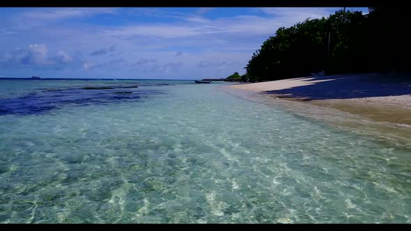 Aerial drone shot travel of idyllic resort beach voyage by aqua blue lagoon with white sand backgrou