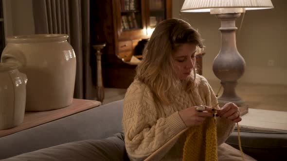 Young woman knitting at home