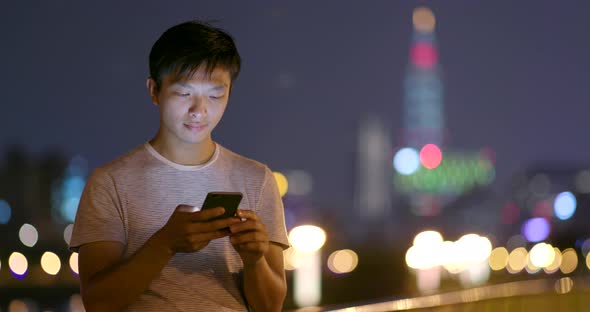 Man use of mobile phone in the city at night