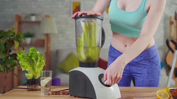 Young Athletic Woman Throws Celery in the Mixer Slow Mo