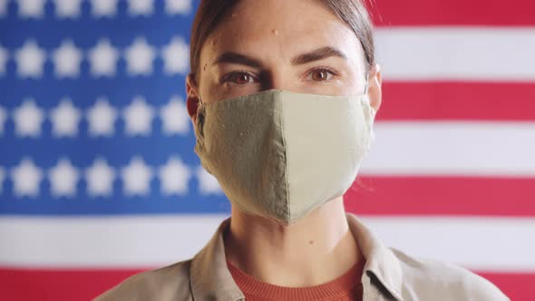 Portrait of Young Woman in Face Mask Posing on U.S. Flag