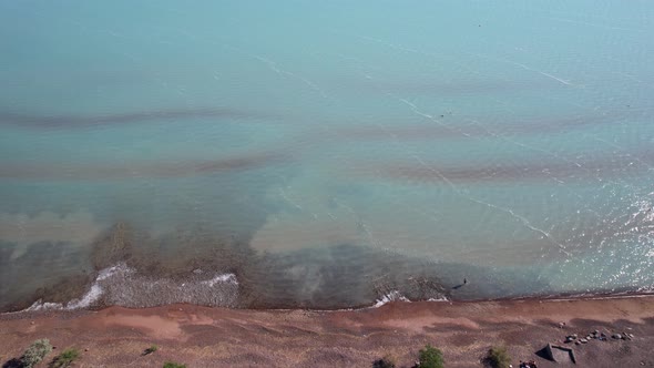 A Beach with Blue Water Color and Sandy Waves