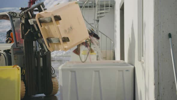 Cod catch of the day being tipped into another container with a forklift