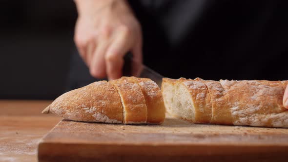 Female Baker Cutting Homemade Bread at Bakery