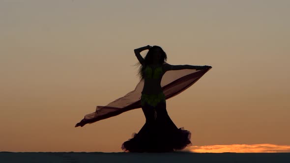 Girl on the Seashore Gracefully Dances Her Body Against the Sunset, Silhouette