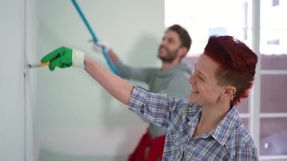 Side View Woman Talking with Man Painting Wall in New House