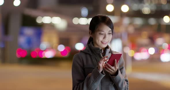 Woman Use of Mobile Phone Online in The City at Night