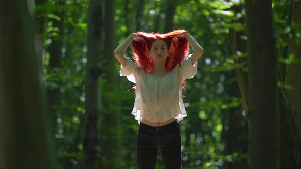 Girl with long red hair in a forest