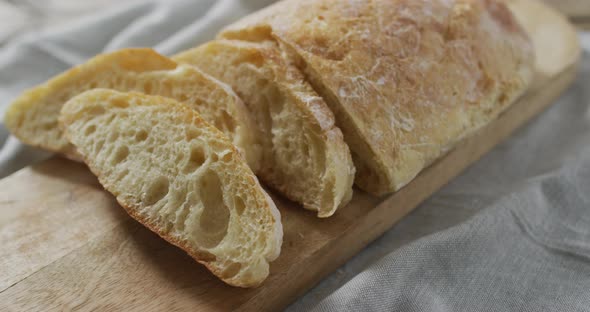 Video of bread on chopping wooden board on wooden worktop