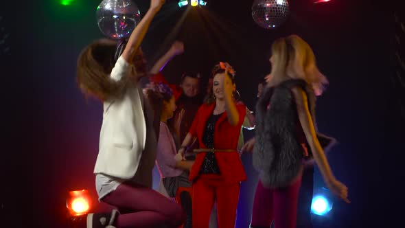 Group of Young People Dancing with Raised Arms To the Music