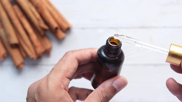 Dropping Cinnamon Essential Oil in a Container