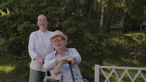 Smile of Nurse and Old Man in Wheelchair