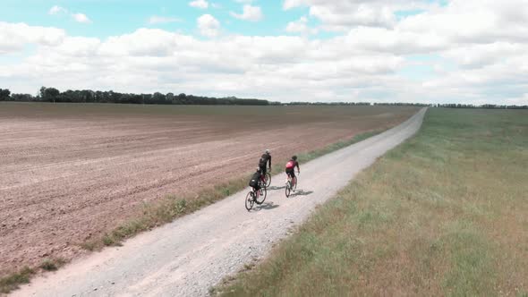 Cyclists riding on gravel bicycles on rural road at countryside