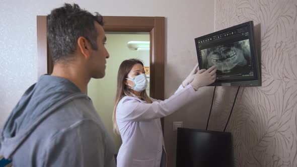 Dentist gives information to his patient via x-ray.