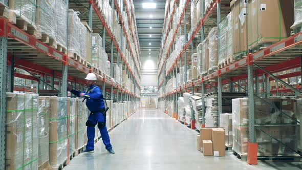 Storage Worker in Ergoskeleton is Displacing Cardboard Boxes